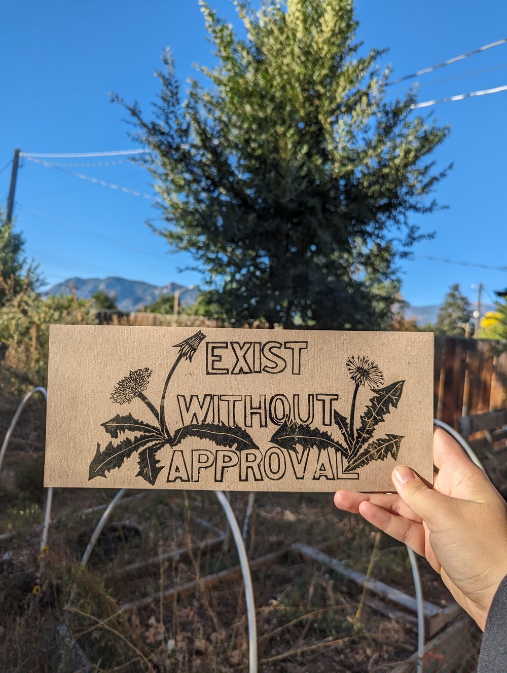 Person holding a cardboard sign with the message 