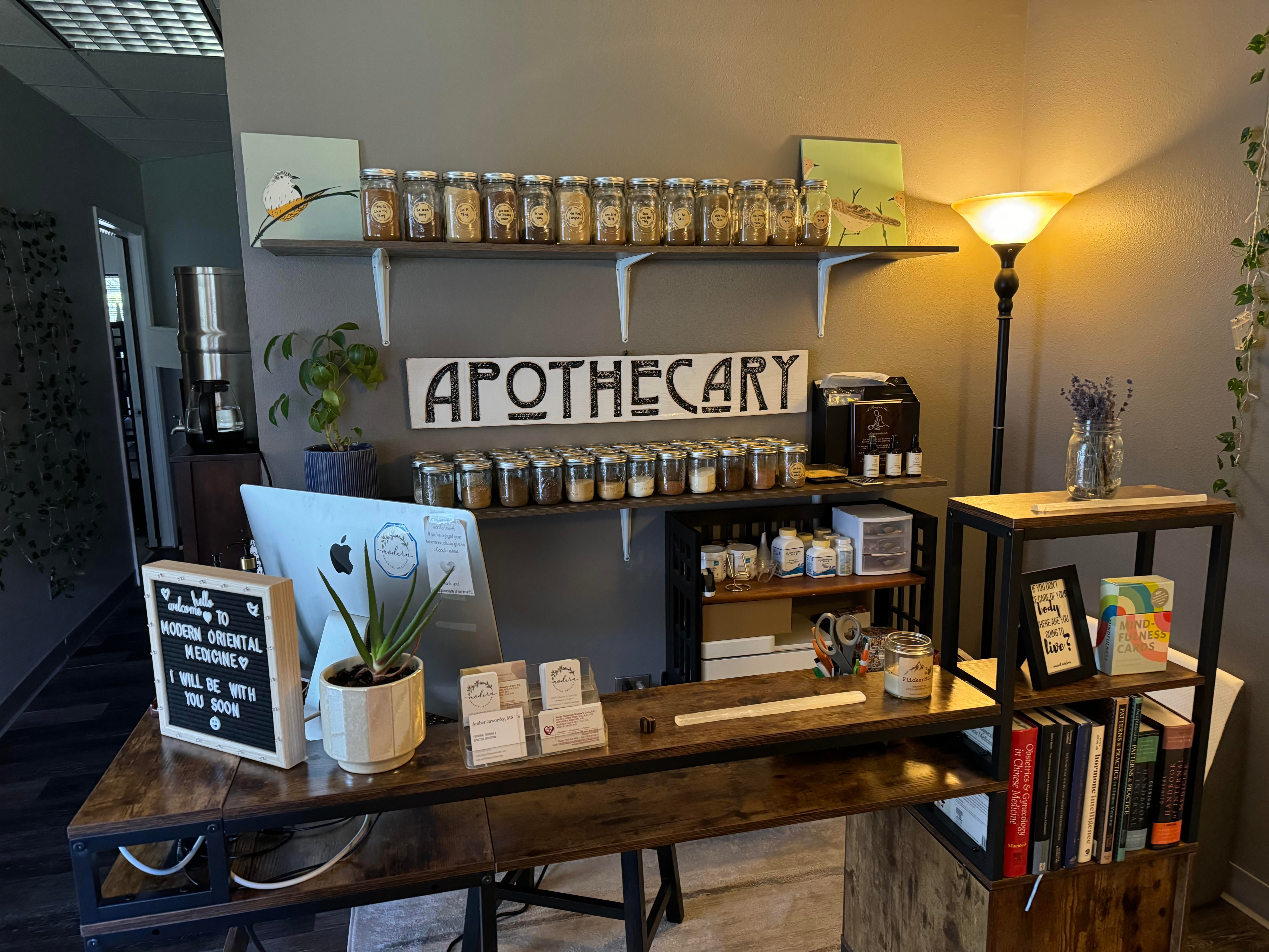 Interior of a pharmacy with shelves of jars, a sign reading 'APOTHECARY,' and a wooden counter with plants and books.