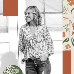 Woman smiling, standing indoors with windows in background, wearing floral blouse and jeans, surrounded by decorative shapes.